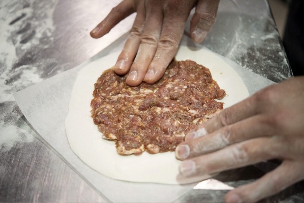 将一部分填充物均匀地涂抹在煎饼上，然后用另一个煎饼覆盖。