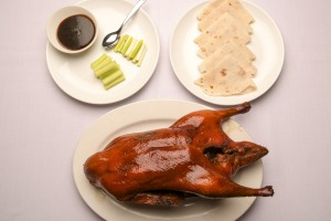 标志性的北京鸭会呈桌面，然后搅拌并组装成煎饼。